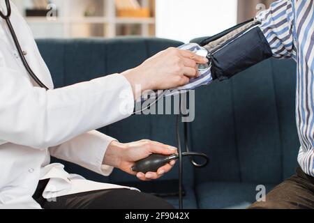 Female Nurse Doing Blood Pressure Measurement Of A Senior Woman Patient