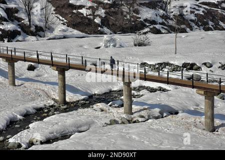 A Kashmiri Man Walks Along A Snow Covered Path On A Cold Winter Day In