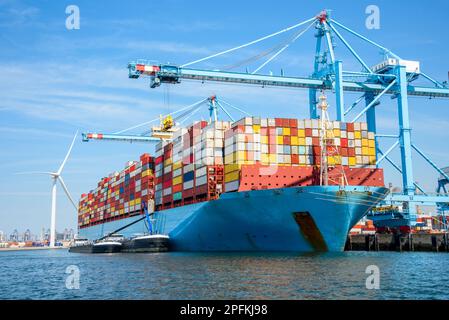 A Large Cargo Ship Loaded With Colorful Containers Is Docked At A Port