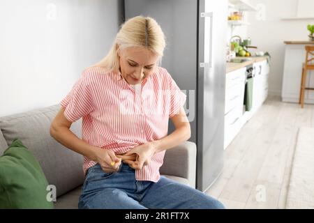 Mature Diabetic Woman Giving Herself Insulin Injection At Home Stock