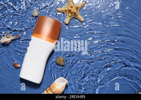 Sunscreen Cream With Starfishes And Seashells In Water On Color