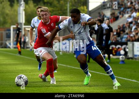 Jayden Fevrier Of Colchester United Looks To Get Past Louis Reed Of