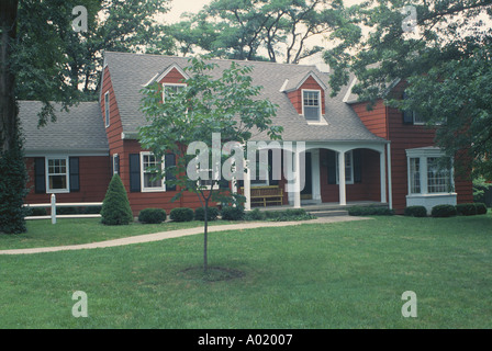 Front yard of a red painted house piled up with junk as an exhibition