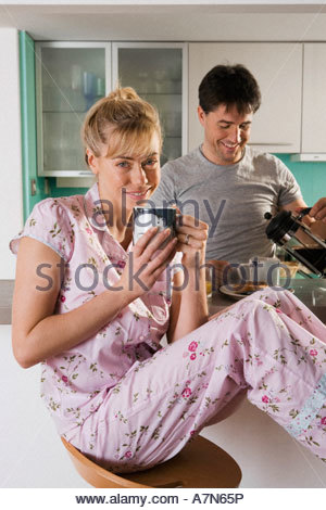 http://l450v.alamy.com/450v/a7n65p/couple-sitting-at-kitchen-breakfast-bar-woman-with-feet-up-man-pouring-a7n65p.jpg
