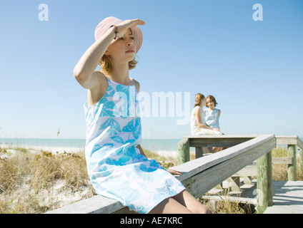 Preteen Girl Sitting On Beach With Barefeet Hugging Knees Stock Photo