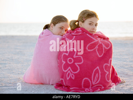 Preteen Girl Sitting On Beach With Barefeet Hugging Knees Stock Photo