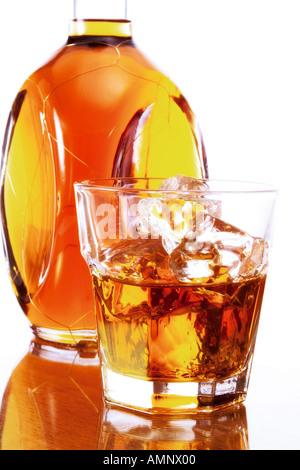 A Whiskey Cream Bottle And Glass With Ice Cubes Reflected On White