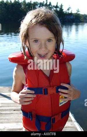 A Girl Standing On A Dock Wearing A Bikini Top And Holding A Stock