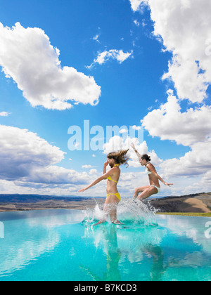 Two Women In Bikini Jumping With Their Hands Up Stock Photo Alamy