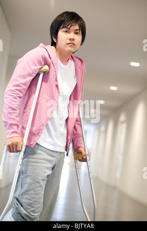 A Man With A Broken Leg On Crutches Against A White Background Stock