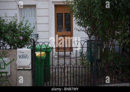 Apartment Building Front Door paris, france, plastic wheely trash bins in front of apartment Apartment Building Front Door paris, france, plastic wheely trash bins in front of apartment