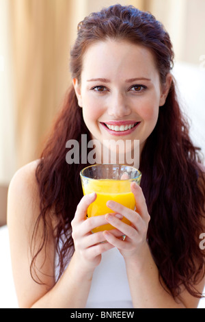 http://l450v.alamy.com/450v/bnreew/smiling-woman-drinking-orange-juice-in-bedroom-bnreew.jpg