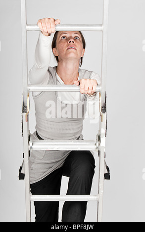 Woman Climbing Up The Ladder Stock Photo Alamy