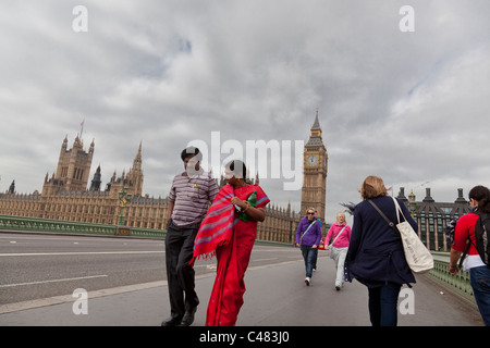 http://l450v.alamy.com/450v/c483j0/man-and-woman-of-asian-decent-walk-over-westminster-bridge-with-big-c483j0.jpg