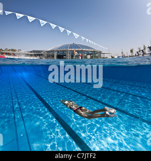 Olympic Swimming Pool Underwater a female swimmer training in an open air olympic swimming pool Olympic Swimming Pool Underwater a female swimmer training in an open air olympic swimming pool