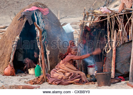 himba-woman-sitting-on-ground-fanning-a-