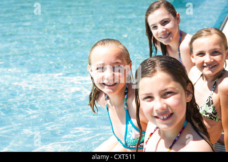 Group Of Girls On The Edge Of A Public Swimming Pool Stock Photo