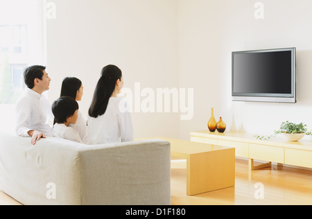 Living Room With Tv And People woman watching large flat screen tv in modern living room stock Living Room With Tv And People woman watching large flat screen tv in modern living room stock