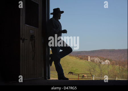 Open Barn Door farmer silhouette in open barn door with farm scenery in Open Barn Door farmer silhouette in open barn door with farm scenery in
