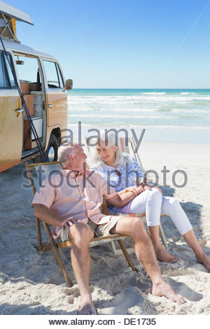 http://l450v.alamy.com/450v/de1735/happy-senior-couple-sitting-in-lounge-chairs-on-sunny-beach-near-van-de1735.jpg