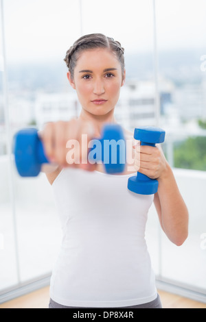 Stern Toned Brunette Holding Dumbbells Stock Photo Alamy