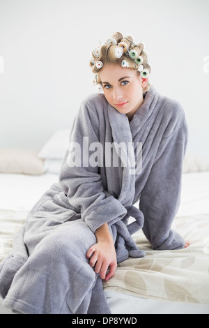 Charming Relaxed Blonde Woman In Hair Curlers Using A Tablet Pc Stock