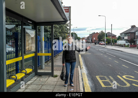 Lady waiting at the bus stop for a bus to come along Stock ...