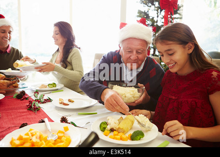 Senior Man Using A Digital Tablet With His Wife Sitting On A Sofa At