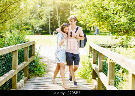 http://l450v.alamy.com/450v/e705b2/couple-walking-over-wooden-bridge-in-the-park-e705b2.jpg