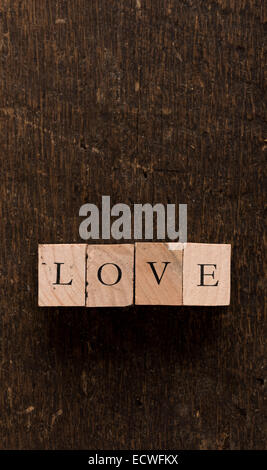 Stamping Blocks With The Word LOVE Spelled Out Set On Rustic Wood Stamping Blocks With The Word LOVE Spelled Out Set On Rustic Wood