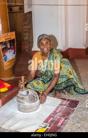 Old woman grinding rice flour at DakshinaChitra Heritage Museum near