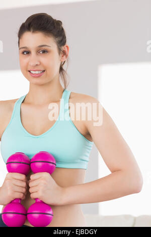 Smiling Toned Brunette Holding Dumbbells Stock Photo Alamy