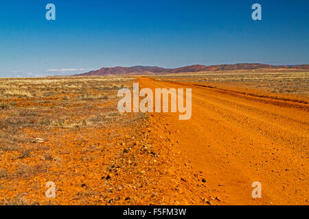 Road Stretching Across Vast Red Stony Barren Plains That Stretch To