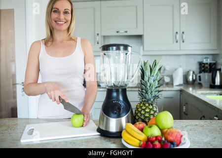 Pretty Blonde Woman Preparing A Smoothie With Recipe On Laptop Stock