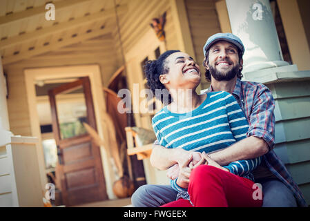 http://l450v.alamy.com/450v/fwgeex/a-couple-a-man-and-woman-seated-on-the-porch-steps-laughing-fwgeex.jpg