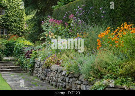 Colourful planting in a raised flower bed of a patio garden Stock Photo