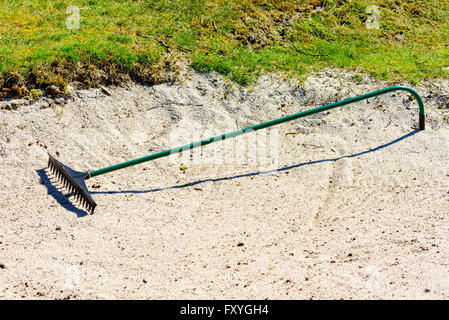 Rake in a golf course sand bunker Stock Photo, Royalty Free Image