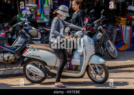 Girl In Mask To Protect Her From Polution On Motor Scooter Siem Reap Cambodia Girl In Mask To Protect Her From Polution On Motor Scooter Siem Reap Cambodia