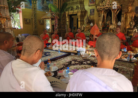 Seated Buddhist Monks Chanting And Reading Prayers At A Ceremony Wat