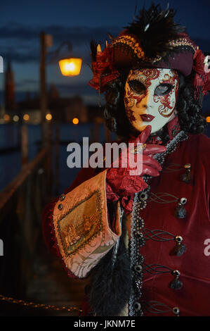 Female Mask wearer at the Carnival of Venice with red Coat and Red ...