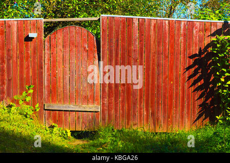 Front yard of a red painted house piled up with junk as an exhibition