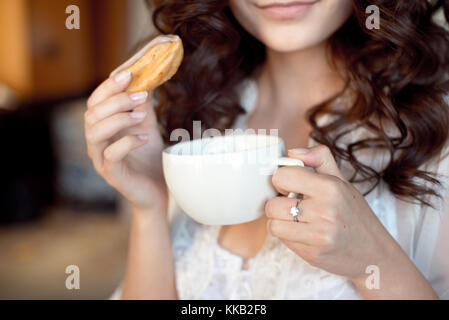 http://l450v.alamy.com/450v/kkb2f8/close-up-of-the-hands-of-a-woman-holding-a-white-cup-of-coffee-and-kkb2f8.jpg