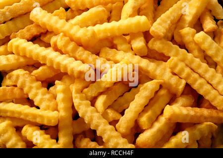 Close Up Background Of Crinkle Cut Crispy Golden Fried Potato Chips