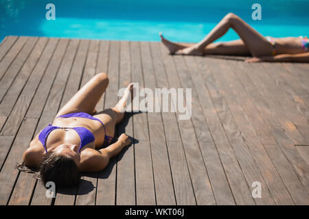 Women In Bikinis Lying Poolside Sunbathing On A Sunny Day Stock Photo Alamy