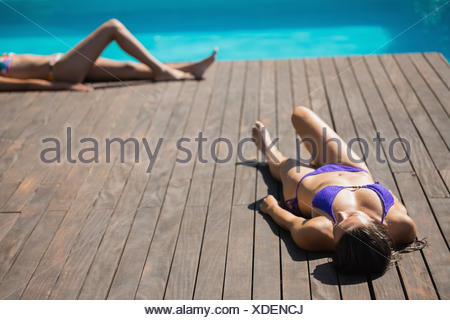 Women In Bikinis Lying Poolside Sunbathing On A Sunny Day Stock Photo Alamy