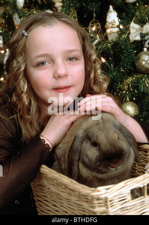 Weißes Kaninchen mit einem Geschenk unter dem Baum als Symbol des neuen