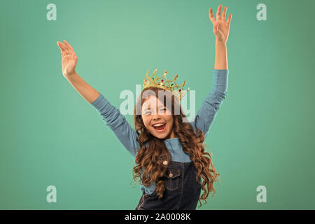 Feels like queen. Kid wear golden crown symbol of princess. Lady little princess. Girl cute baby wear crown while stand blue background. Childhood concept. Every girl dreaming to become princess. Stock Photo