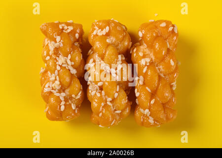 top view traditional Chinese twisted deep fried doughs on yellow background Stock Photo