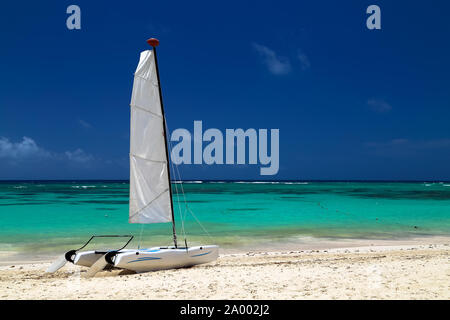 Catamaran on the exotic coast of the Atlantic Ocean with a background from golden sand of emerald water and the blue sky. Beautiful Carribean sea, pan Stock Photo