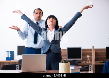 The two employees doing sport exercises in the office Stock Photo